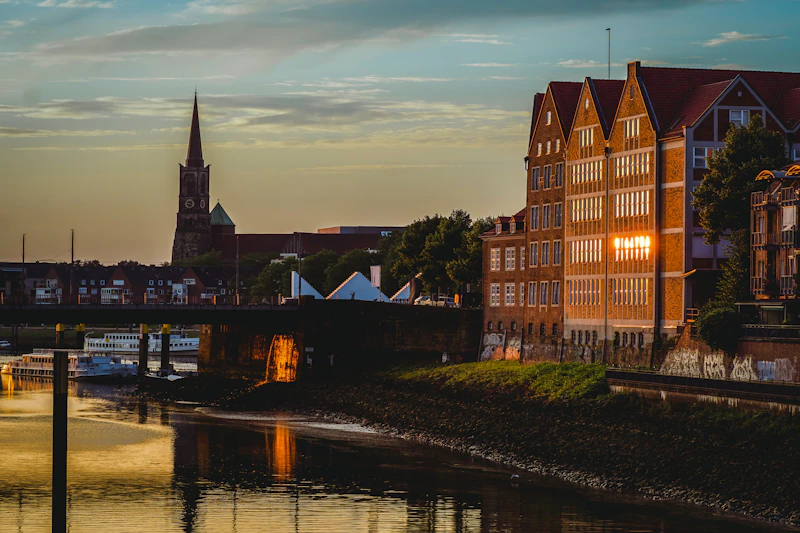 A view of a river with a bridge and buildings in the background