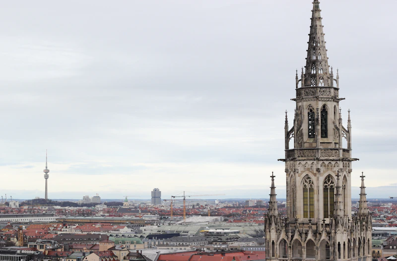 Gothic spire overlooks a city skyline with tower